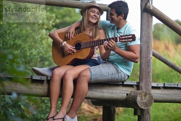 Teenagerpaar beim Gitarre spielen und singen