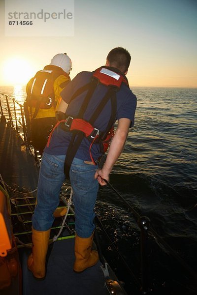 Rettungsbootbesatzung  die vom Rettungsboot aus auf das Meer blickt.