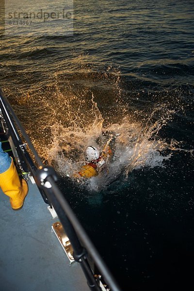 Rettungsboot-Crew-Training mit Teammitglied im Meer