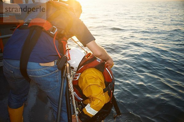 Ausbildung der Rettungsbootbesatzung und Einholen von Teammitgliedern aus dem Meer