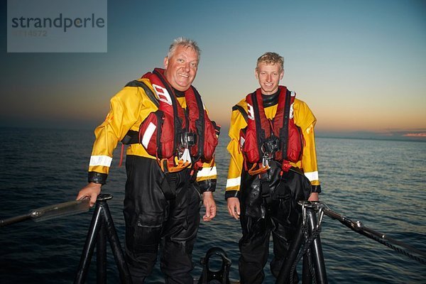 Porträt von zwei Männern  die ein Rettungsboot auf See besetzen