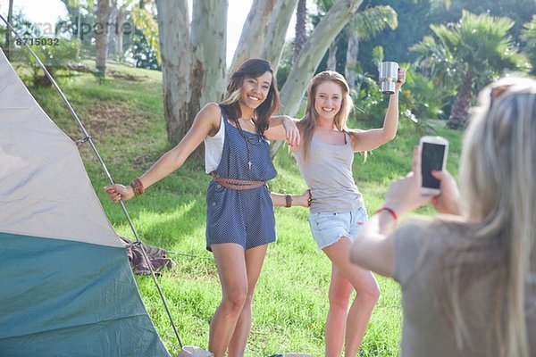 Drei junge Freundinnen beim Fotografieren auf dem Smartphone