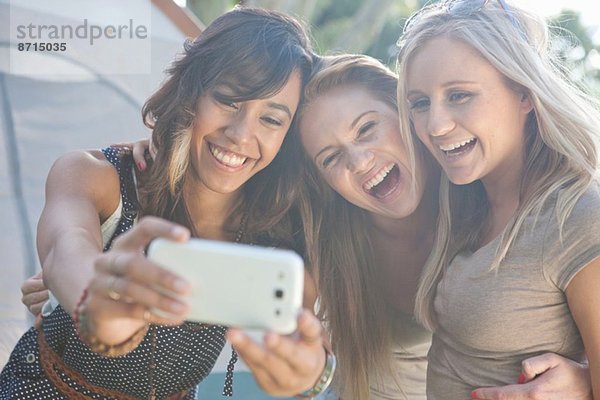 Drei junge Freundinnen  die einen Selfie mit Smartphone nehmen