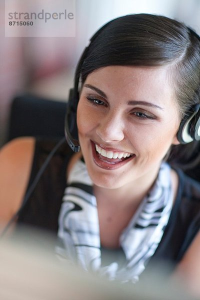 Junge Büroangestellte chatten am Headset