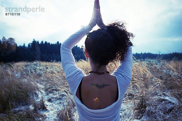 Mittlere erwachsene Frau praktiziert stehende Baum-Yoga-Pose