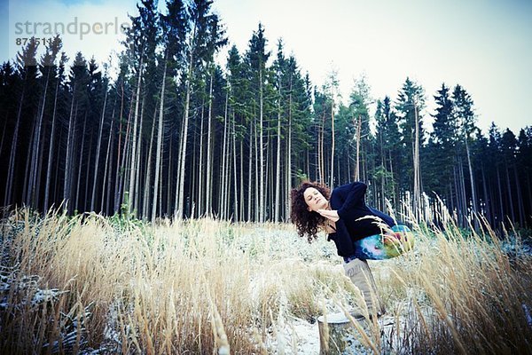 Mittlere erwachsene Frau  die Yoga-Bewegungen im Wald praktiziert.