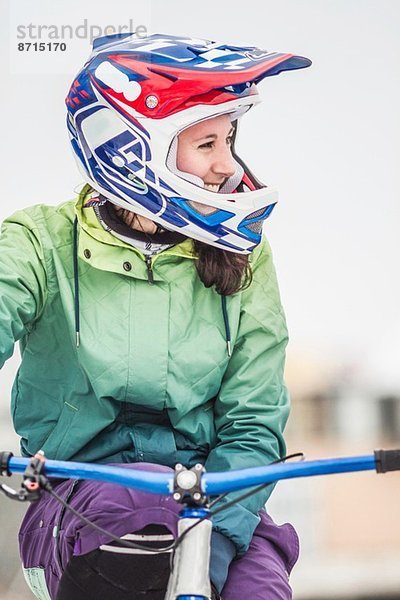 Lächelnde junge erwachsene Mountainbikerin auf dem Fahrrad