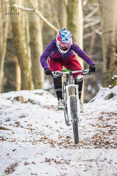 Junge Mountainbikerin im Winterwald