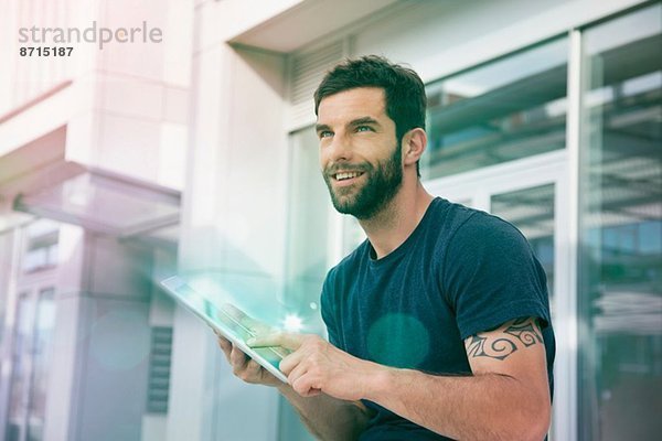 Mittlerer Erwachsener Mann mit Touchscreen auf digitalem Tablett mit Beleuchtung