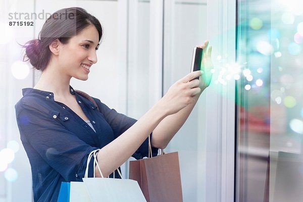 Junge Geschäftsfrau schaut auf das Smartphone mit dem Licht  das aus ihm kommt
