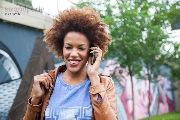 Junge Frau spricht auf dem Smartphone