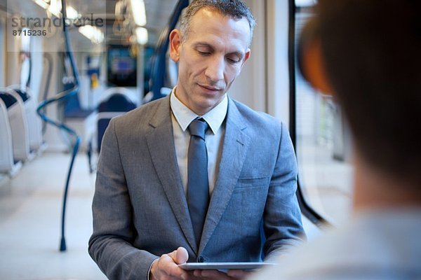Geschäftsmann mit digitalem Tablett im Zug