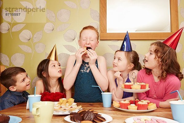 Mädchen essen Partyessen mit Freunden beim Zuschauen