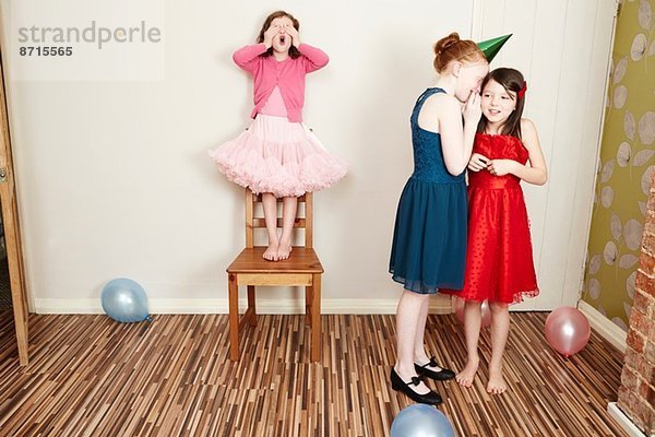 Drei Mädchen beim Verstecken auf der Geburtstagsfeier