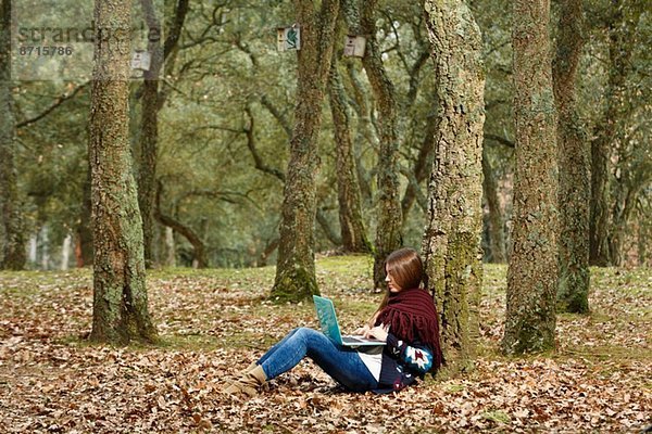 Junge Frau mit Laptop im Wald