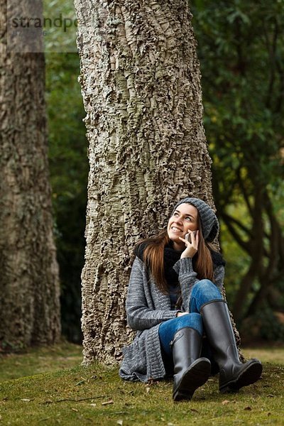 Junge Frau mit Handy im Wald