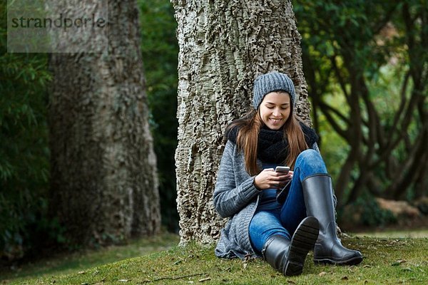 Junge Frau mit Handy im Wald