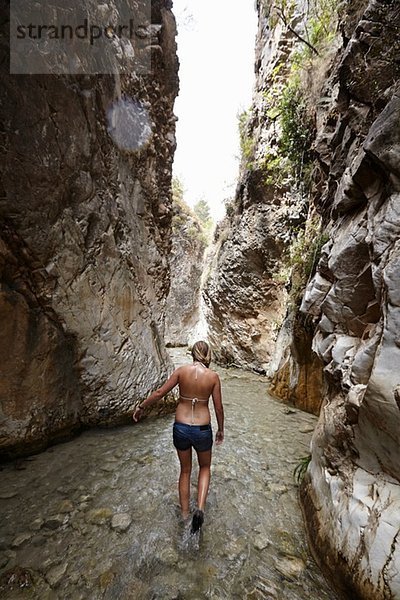 Junge Frau beim Paddeln im Bach zwischen Felsformationen  Costa del Sol  Spanien