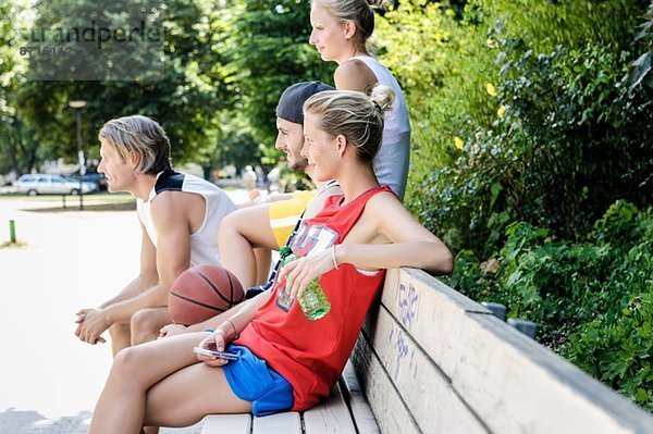 Gruppe von Basketballfreunden bei einer Pause im Park