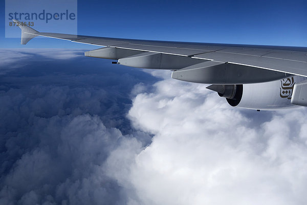 Emirates Fluggesellschaft  Airbus A-380  Flugzeugflügel im Flug über den Wolken