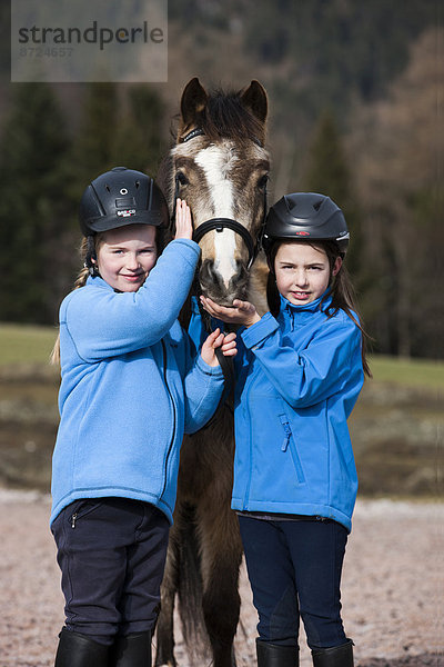 Zwei Mädchen mit einem Pony  Falbe  mit Trense  Tirol  Österreich