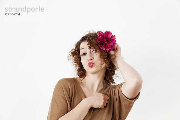 Junge Frau mit Blume im Haar und Kussmund