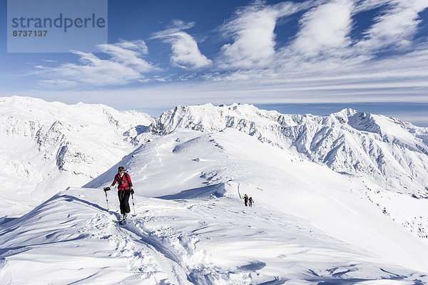 Skitourengeher auf dem Gipfelgrat vom Stotz bei Kurzras im Schnalstal  hinten die Grawand  Südtirol  Italien