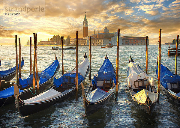 Gondeln am Markusplatz mit der Insel San Giorgio Maggiore hinten  bei Sonnenuntergang  Venedig  Venetien  Italien