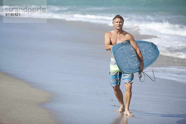 Vereinigte Staaten von Amerika USA Mann gehen Strand Surfboard reifer Erwachsene reife Erwachsene
