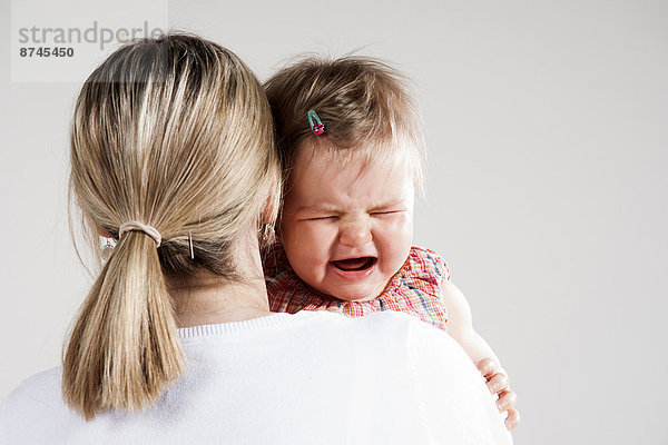 Studioaufnahme  weinen  über  halten  Ansicht  Mädchen  Mutter - Mensch  Baby
