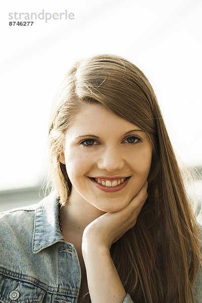 Portrait of young woman outdoors  smiling at camera