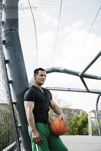 stehend  Portrait  Mann  reifer Erwachsene  reife Erwachsene  Basketball  Außenaufnahme  Gericht  Deutschland