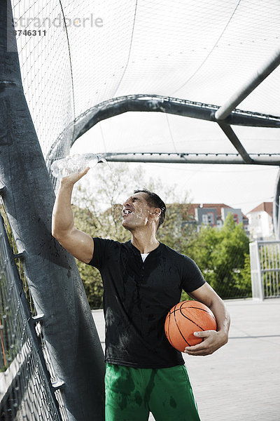 stehend  Wasser  Mann  eingießen  einschenken  reifer Erwachsene  reife Erwachsene  Basketball  Außenaufnahme  Flasche  Gericht  Deutschland