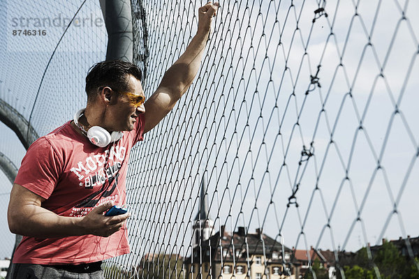stehend  Mann  halten  Spiel  reifer Erwachsene  reife Erwachsene  Basketball  MP3-Player  MP3 Spieler  MP3 Player  MP3-Spieler  Außenaufnahme  Gericht  Deutschland