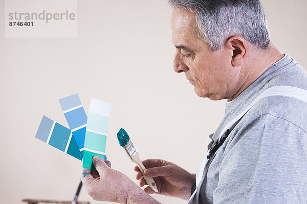 Studioaufnahme  Farbe  Farben  Senior  Senioren  Mann  sehen  Muster  bemalen