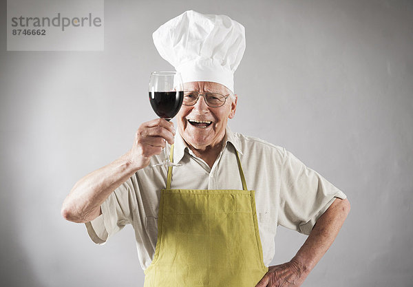 Studioaufnahme Senior Senioren Mann Hut Rotwein Schürze Kleidung Koch