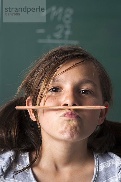 stehend  Portrait  frontal  Klassenzimmer  Mädchen  Schreibtafel  Tafel  Deutschland