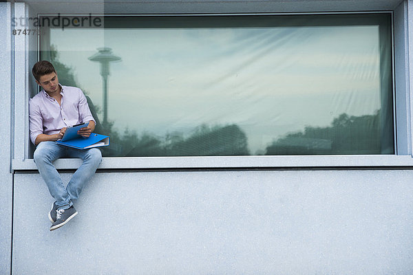 Außenaufnahme  sitzend  Mann  jung  Fenstersims  Deutschland  freie Natur