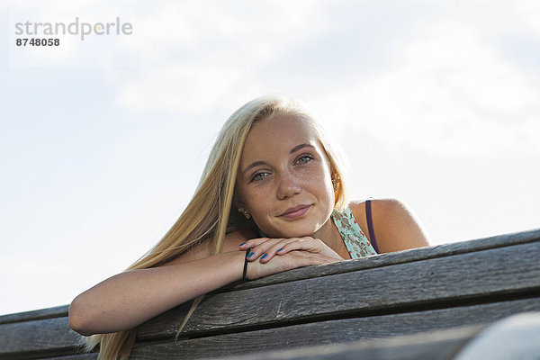 Außenaufnahme  sitzend  Portrait  Jugendlicher  Blick in die Kamera  Sitzbank  Bank  Mädchen  Deutschland  freie Natur