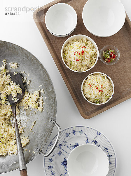 Studioaufnahme Schüssel Schüsseln Schale Schalen Schälchen über Reis Reiskorn kochen Ansicht Wok