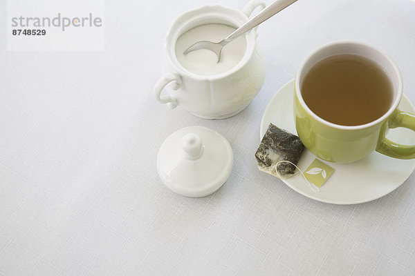 Studioaufnahme  gebraucht  Tasse  Becher  Tasche  grün  Löffel  Zucker  Untertasse  Tee