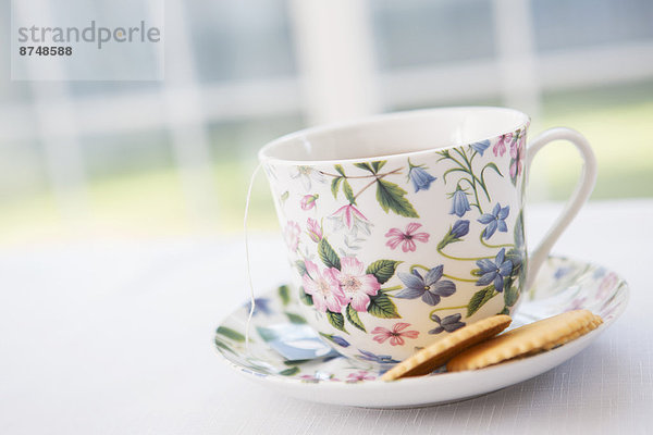 Studioaufnahme  Tasse  Blume  Untertasse  Keks  hübsch  Tee