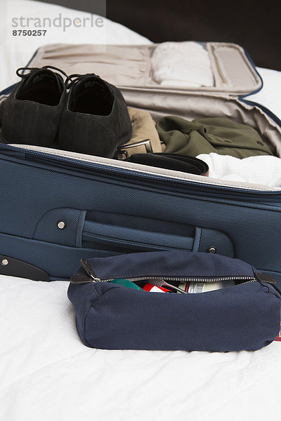 Vereinigte Staaten von Amerika  USA  nebeneinander  neben  Seite an Seite  Mann  Tasche  Bett  Reise  Koffer  verpacken  Hygieneartikel