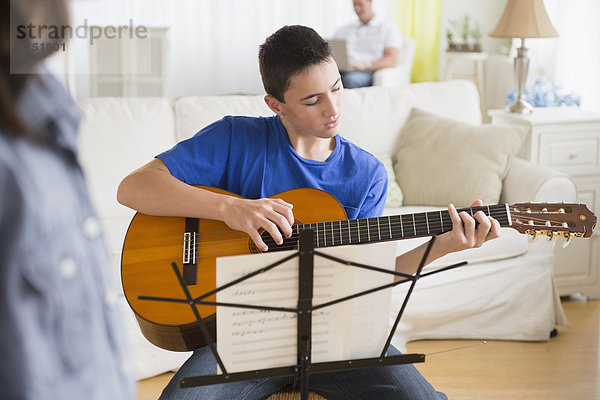 Europäer  Junge - Person  Zimmer  üben  Gitarre  Wohnzimmer