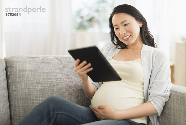 benutzen Frau Couch Schwangerschaft Tablet PC japanisch