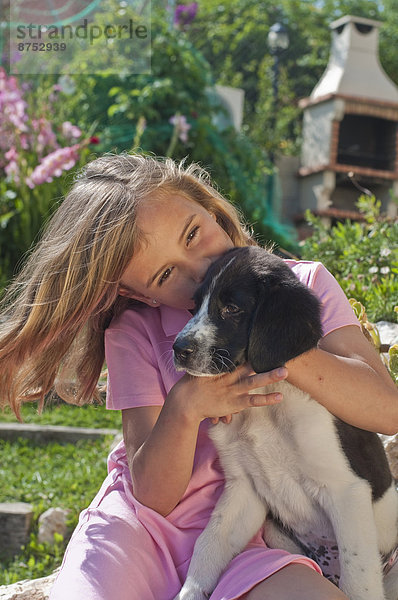 junges Mädchen mit Hund im Garten