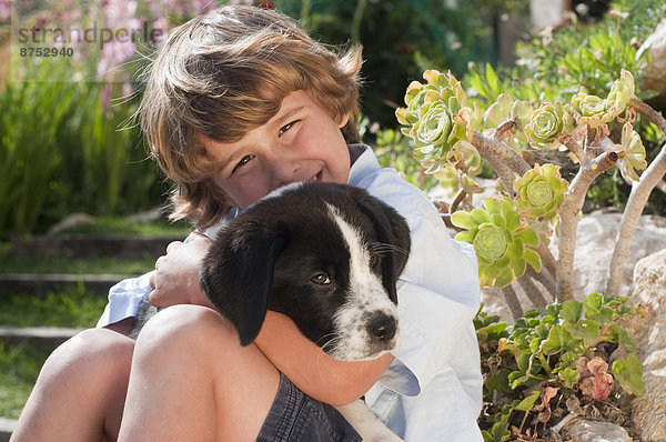 Junge mit Hund im Garten