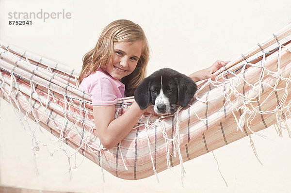 junges Mädchen mit Hund in Hängematte