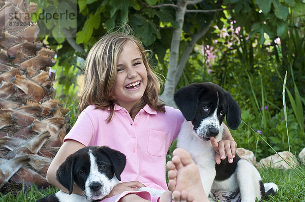 junges Mädchen mit Hunden im Garten