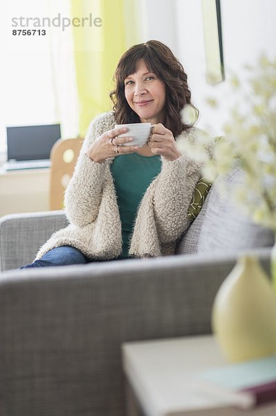 sitzend  Portrait  Frau  Getränk  Couch  Wärme  halten